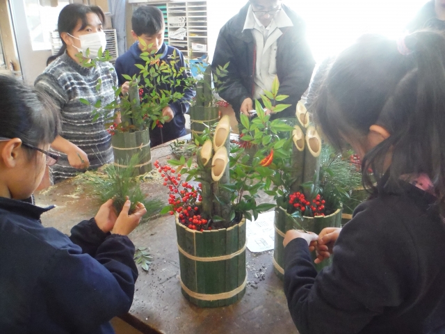 ナンテンやマツを装飾する小学生